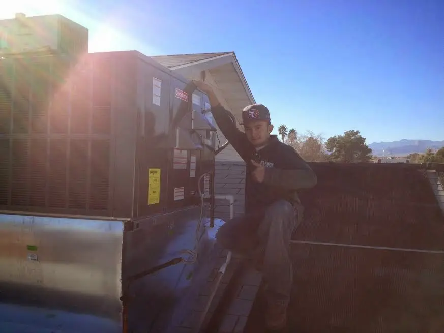 HVAC technician performing Air Duct Cleaning on a rooftop unit in Winslow